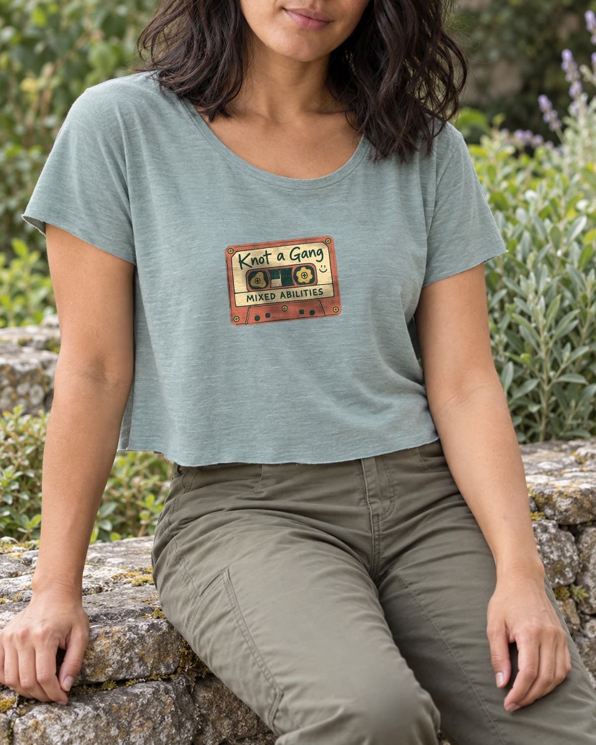 A woman wearing the Stonewash Green Mixed Abilities crop top in a relaxed lifestyle setting.