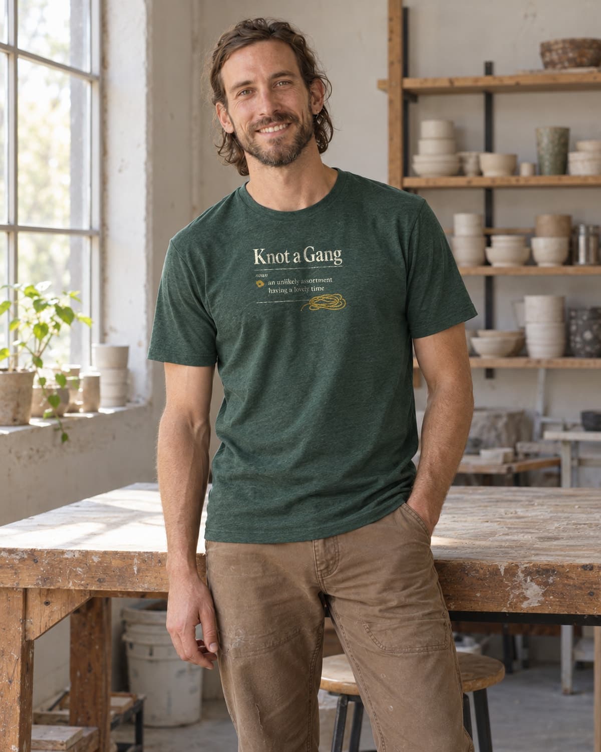 A man wearing the Heather Forest Green A Collective Noun T-shirt in natural studio light.