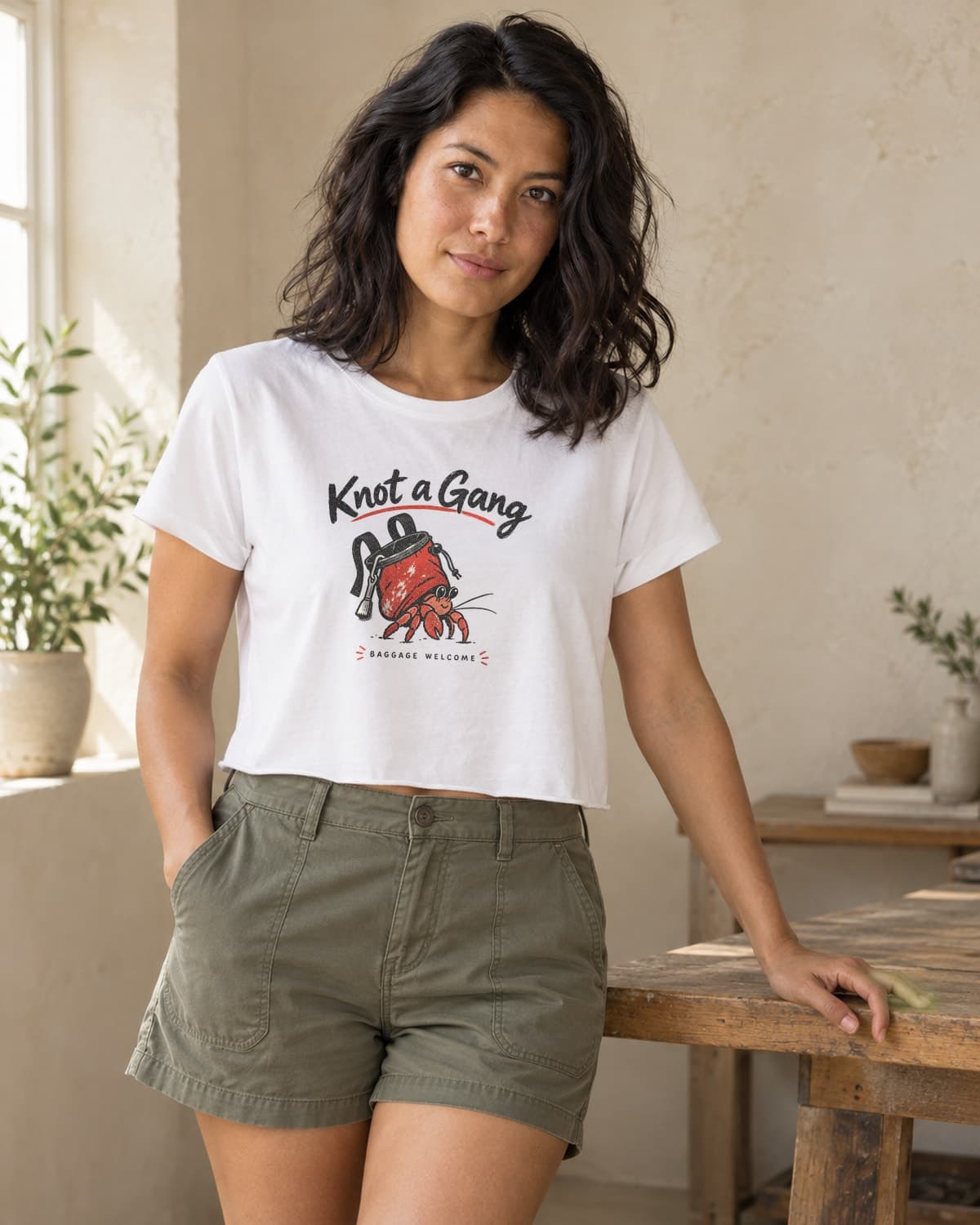 A woman wearing the White Baggage Welcome crop top in natural studio light.