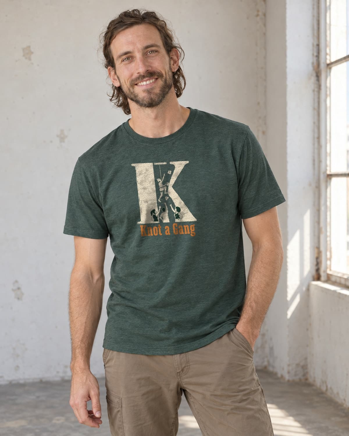 A man wearing the Heather Forest Green The Big K T-shirt in natural studio light.