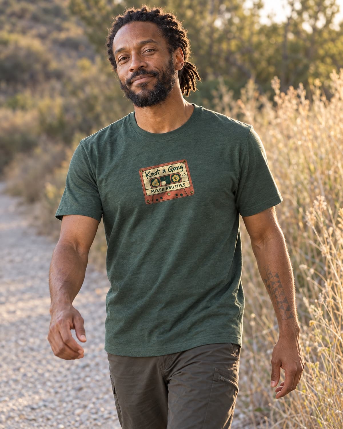 A man wearing the Heather Forest Green Mixed Abilities Mixtape T-shirt in a relaxed lifestyle setting.
