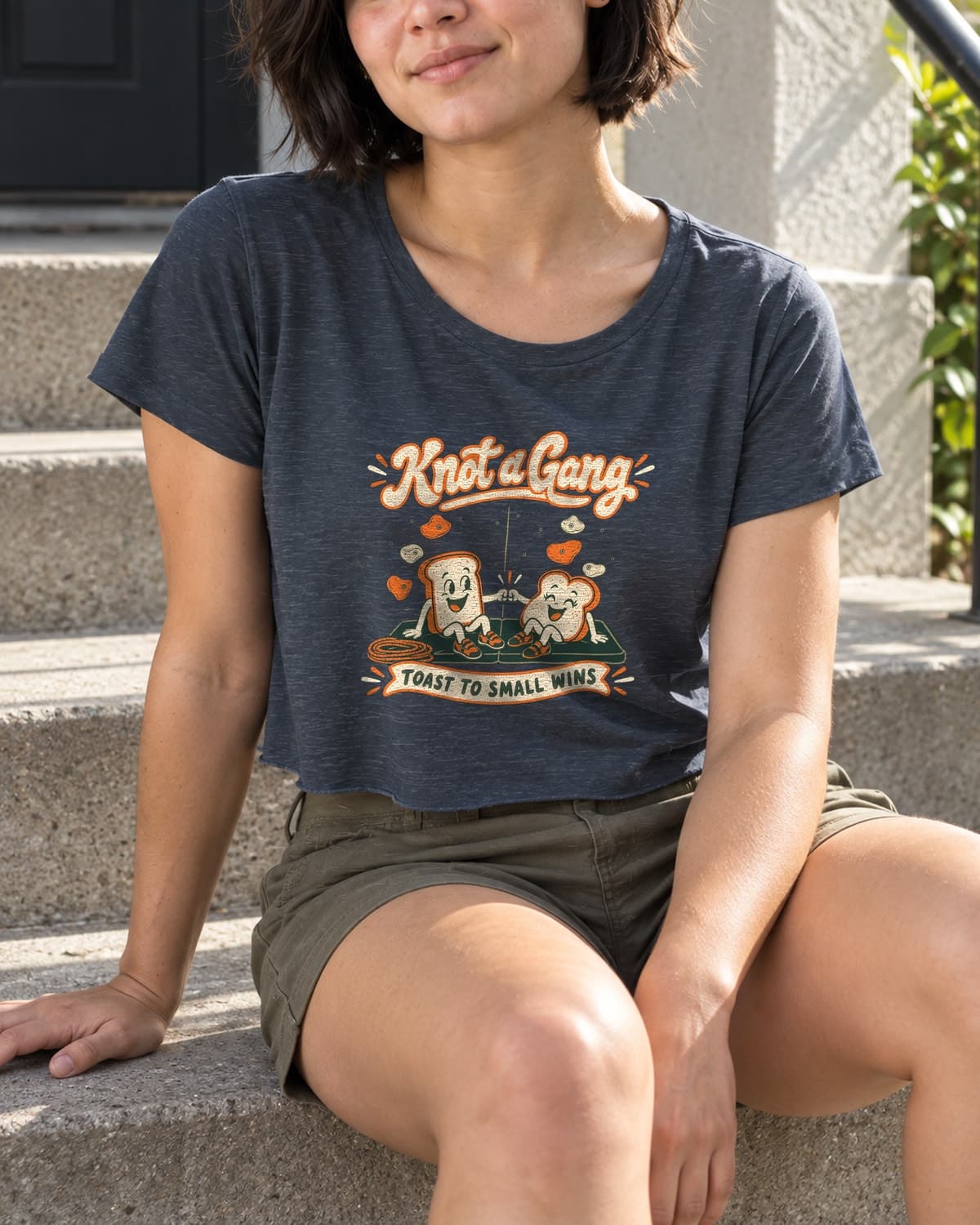 A woman wearing the Antique Denim Toast to Small Wins crop top in a relaxed lifestyle setting.