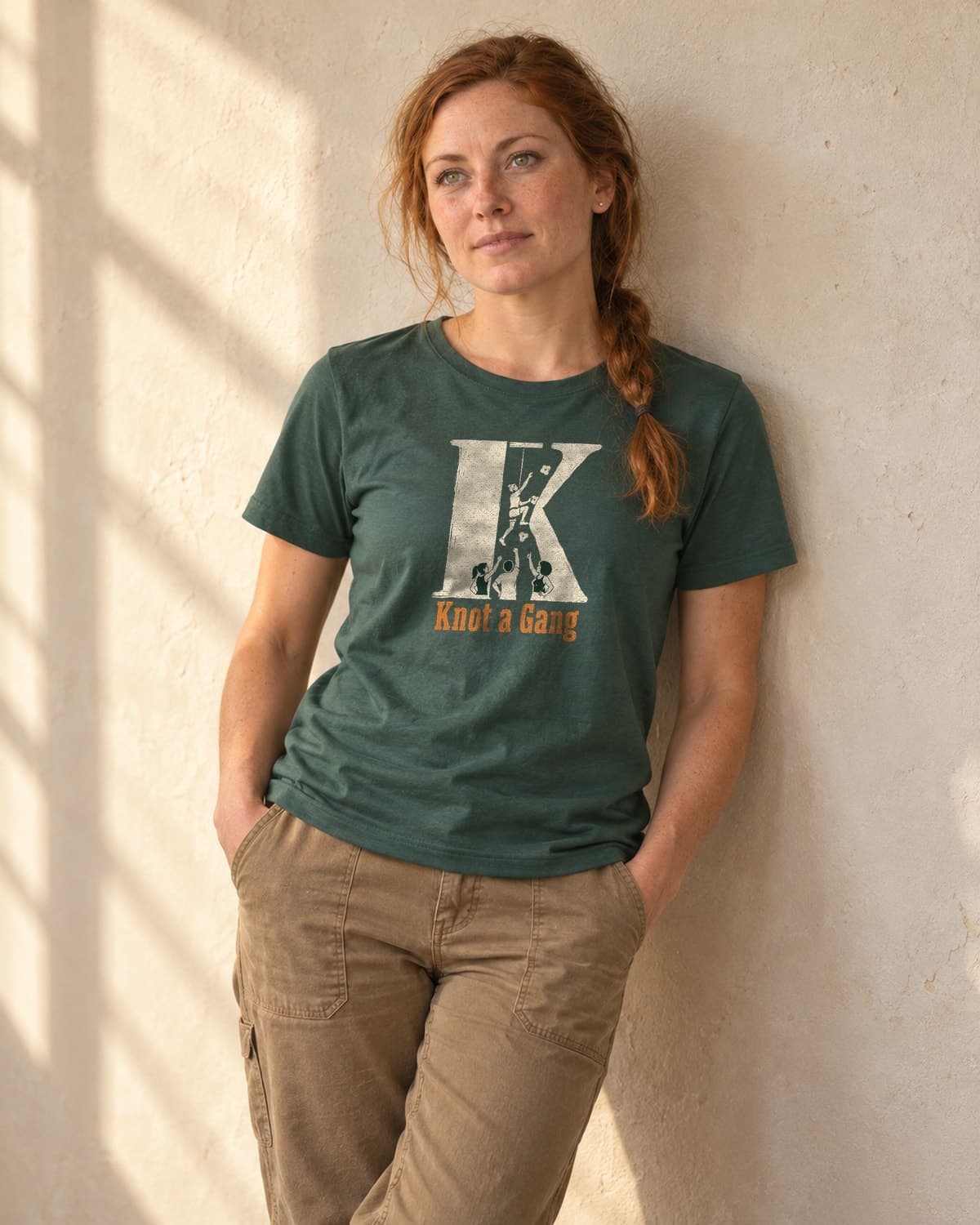 A woman wearing the Heather Forest Green The Big K T-shirt in natural studio light.