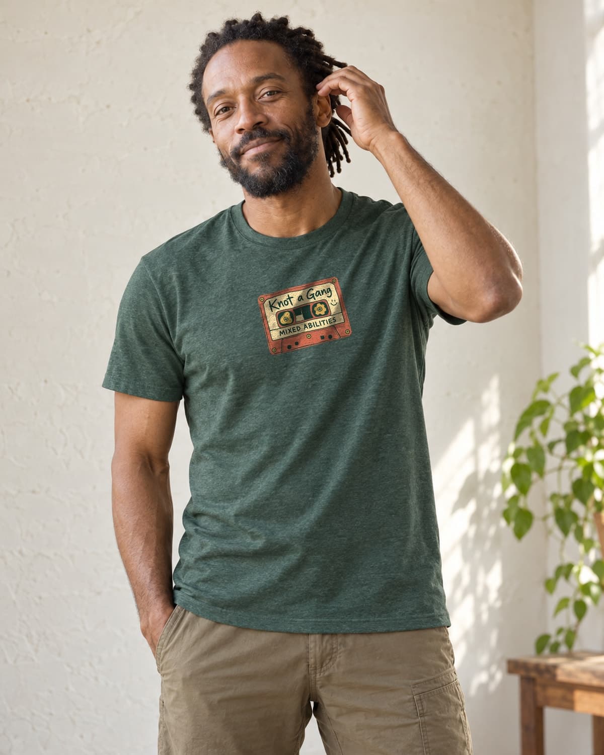 A man wearing the Heather Forest Green Mixed Abilities Mixtape T-shirt in natural studio light.