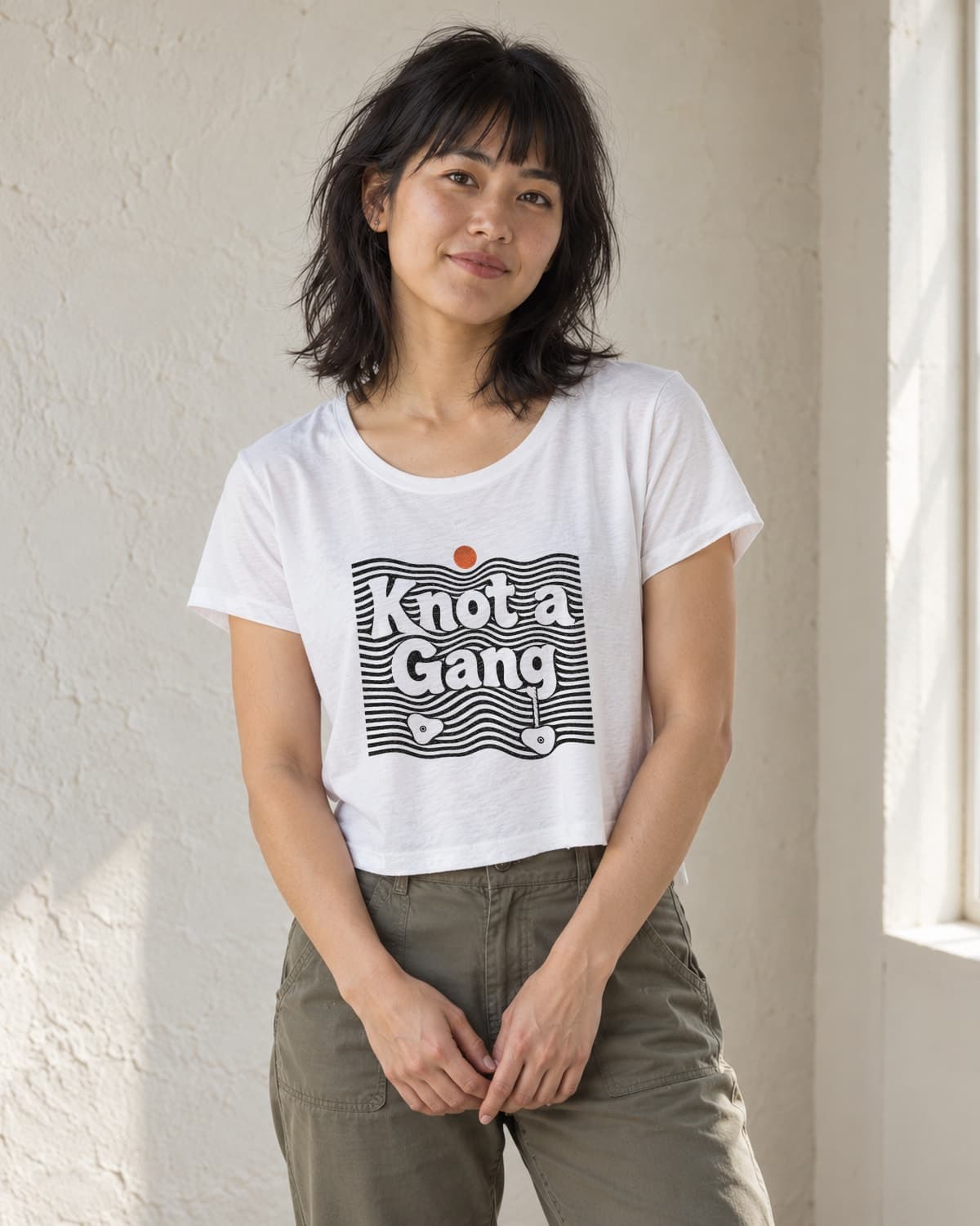 A woman wearing the White Double Take crop top in natural studio light.