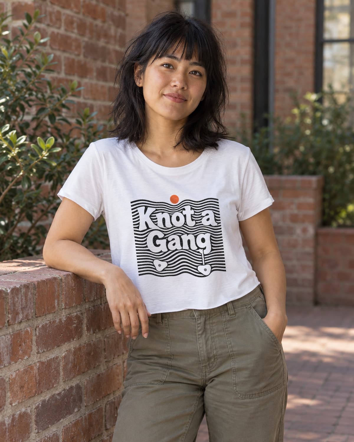 A woman wearing the White Double Take crop top in a relaxed lifestyle setting.