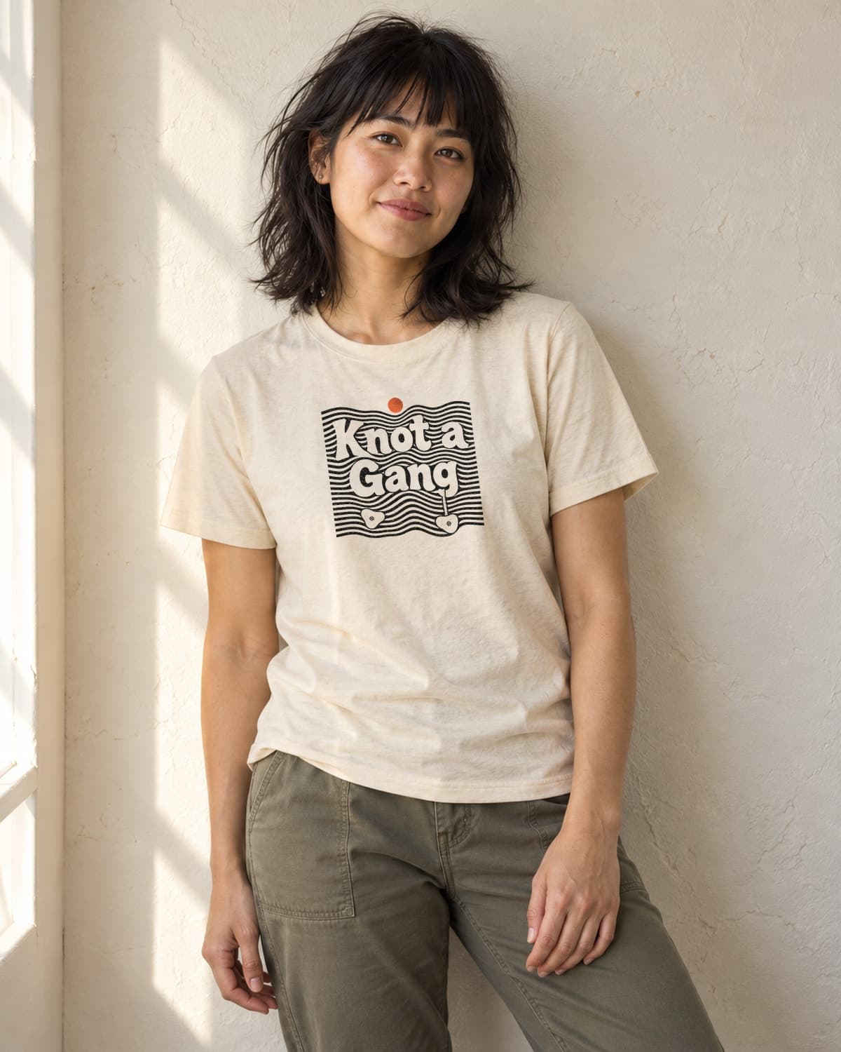 A woman wearing the Cream Double Take T-shirt in natural studio light.