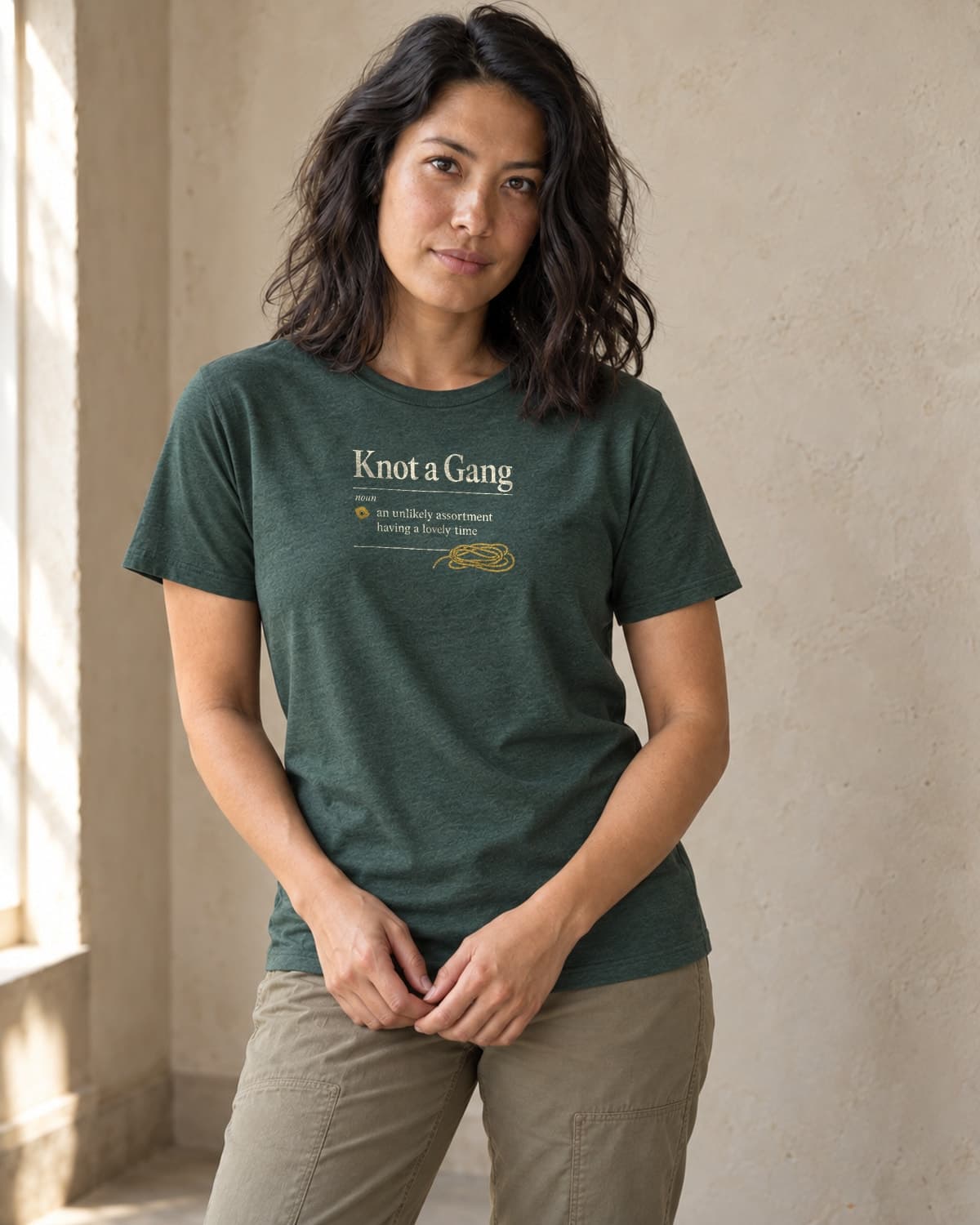 A woman wearing the Heather Forest Green A Collective Noun T-shirt in natural studio light.